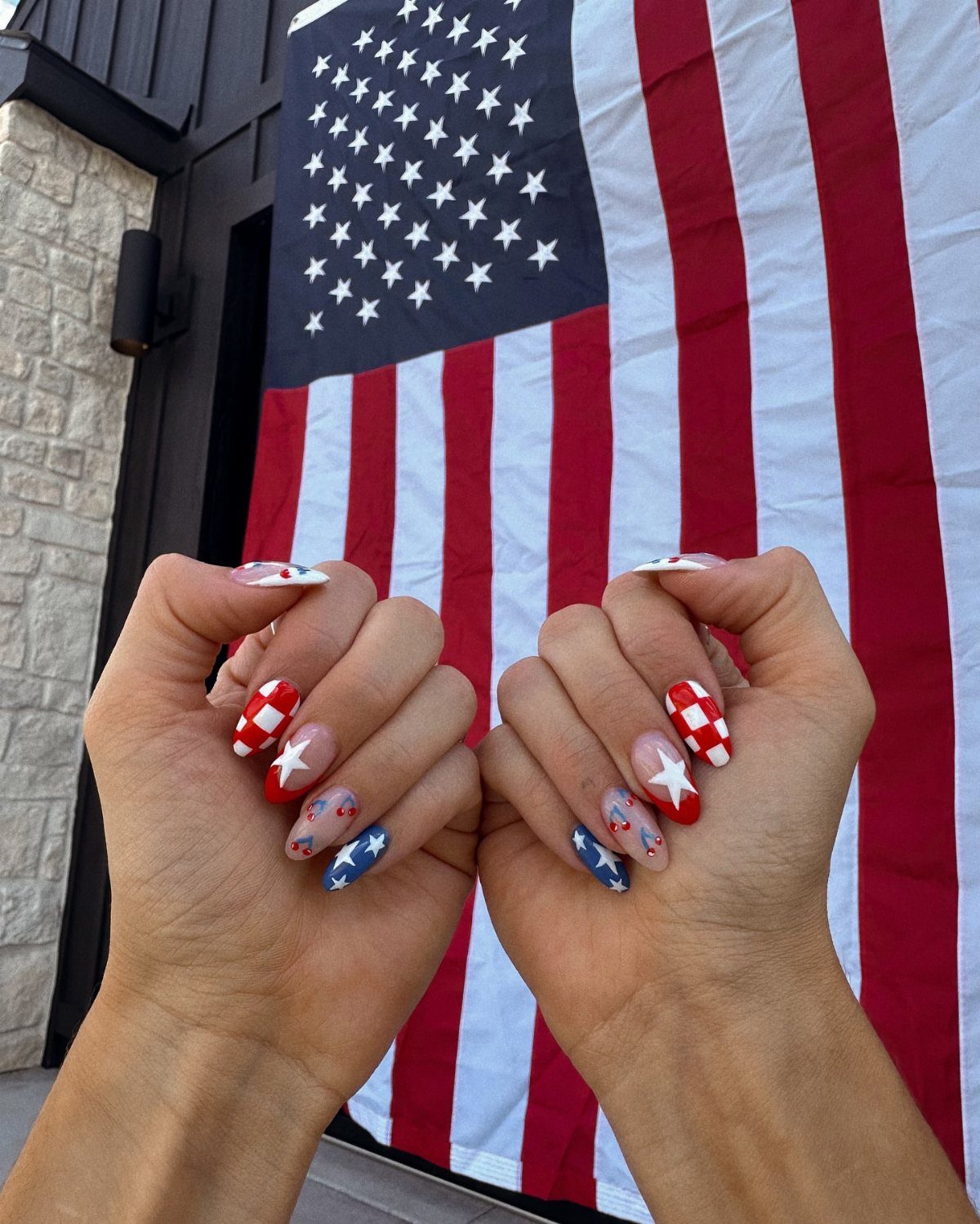 Patriotic red, white, and blue nail art with stars and checkers before American flag