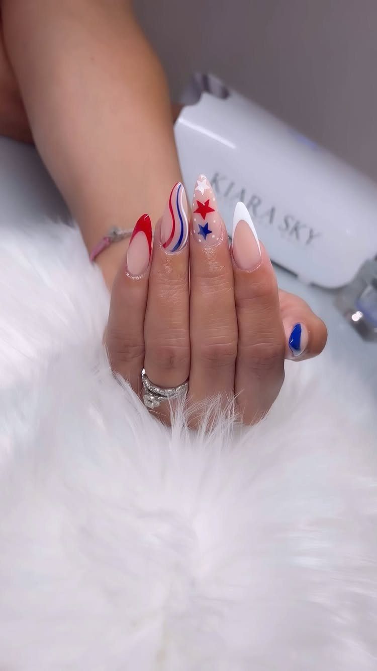 Patriotic red, white, and blue nail art with stars and stripes on almond nails.