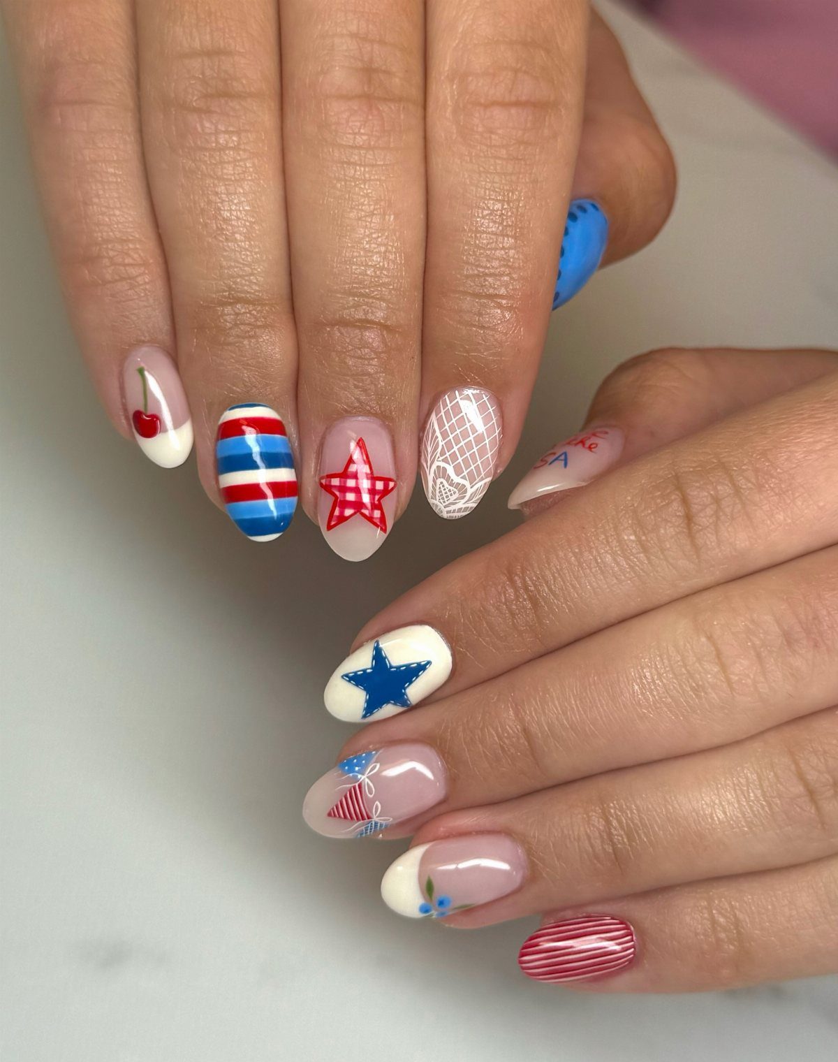 Patriotic red, white, and blue gel nails with stars and stripes designs.