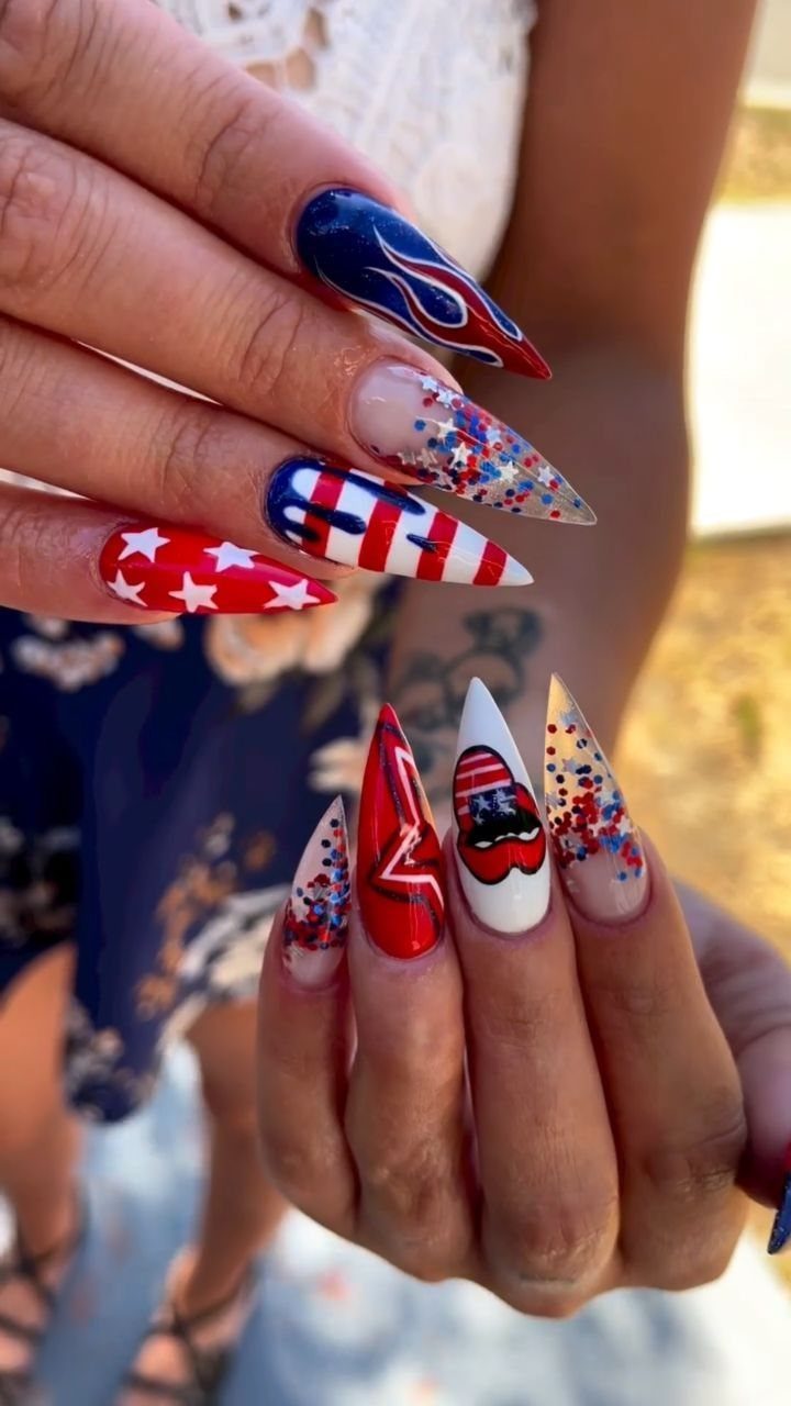 Patriotic red, white, and blue stiletto nails with stars and stripes designs.