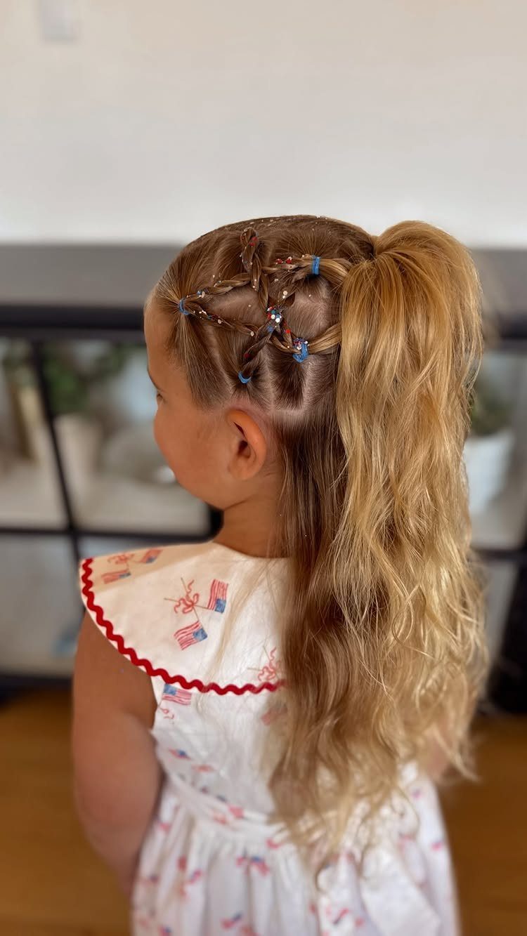 Young girl with blonde ponytail and small braids featuring red, white, and blue beads.