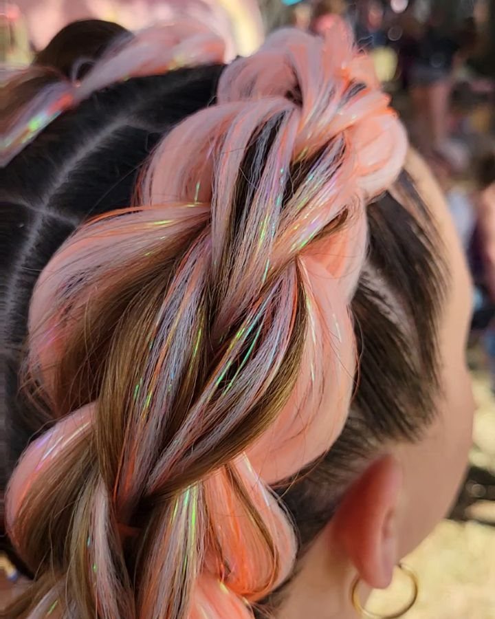 Two thick peach and brown braids with iridescent holographic glitter strands woven in.