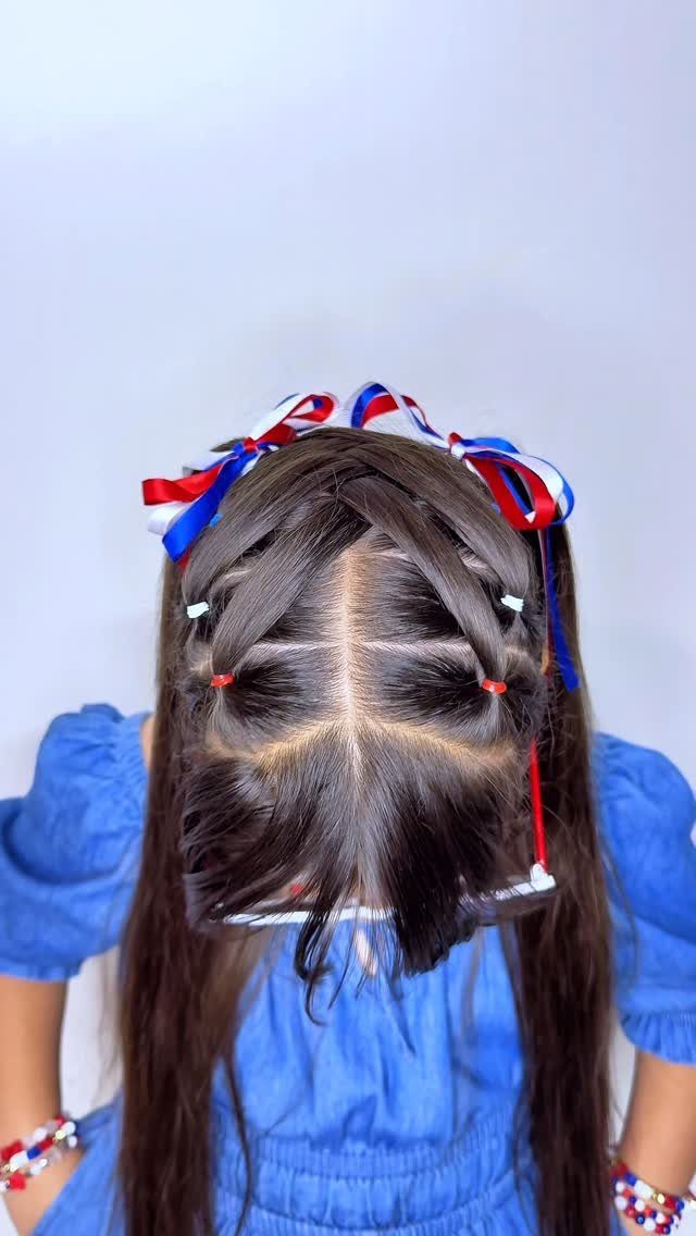 Child's brown hair in pigtails tied with red, white, and blue ribbon bows.