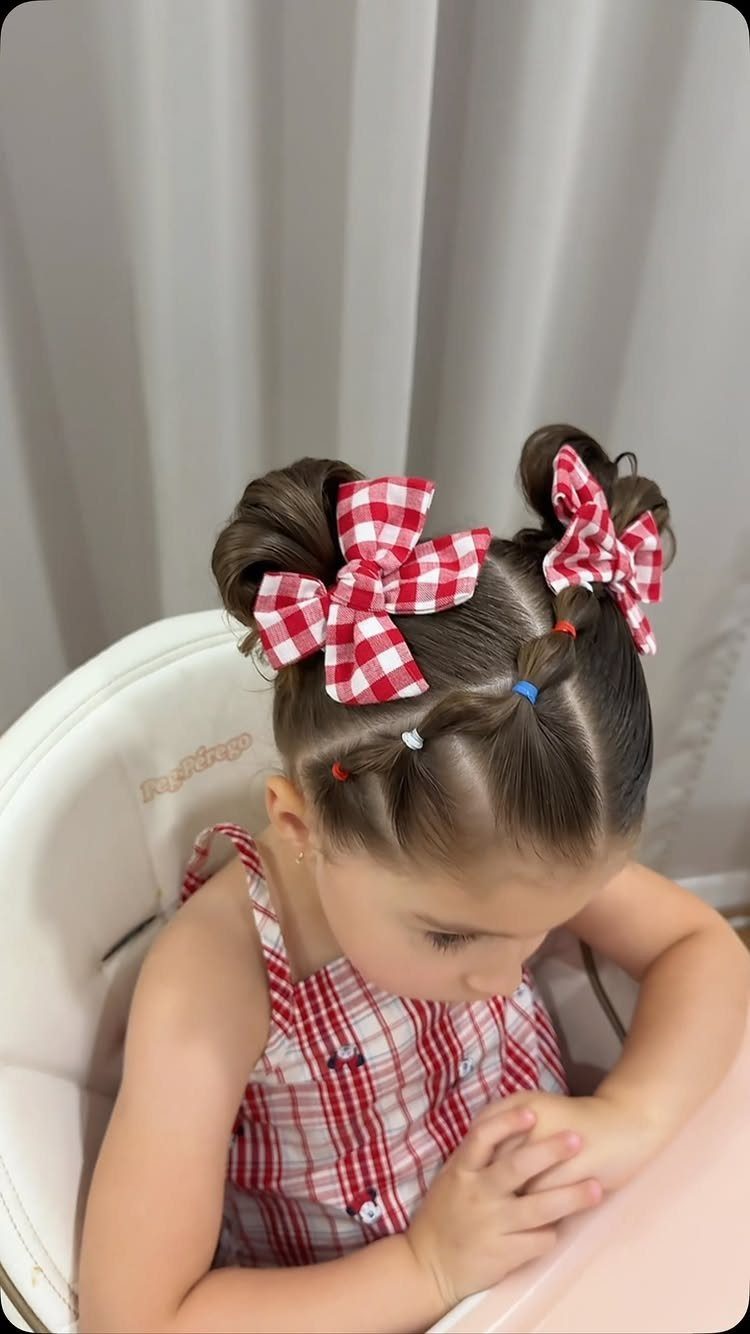 Young girl with twisted buns, red checkered bows, and patriotic hair beads.