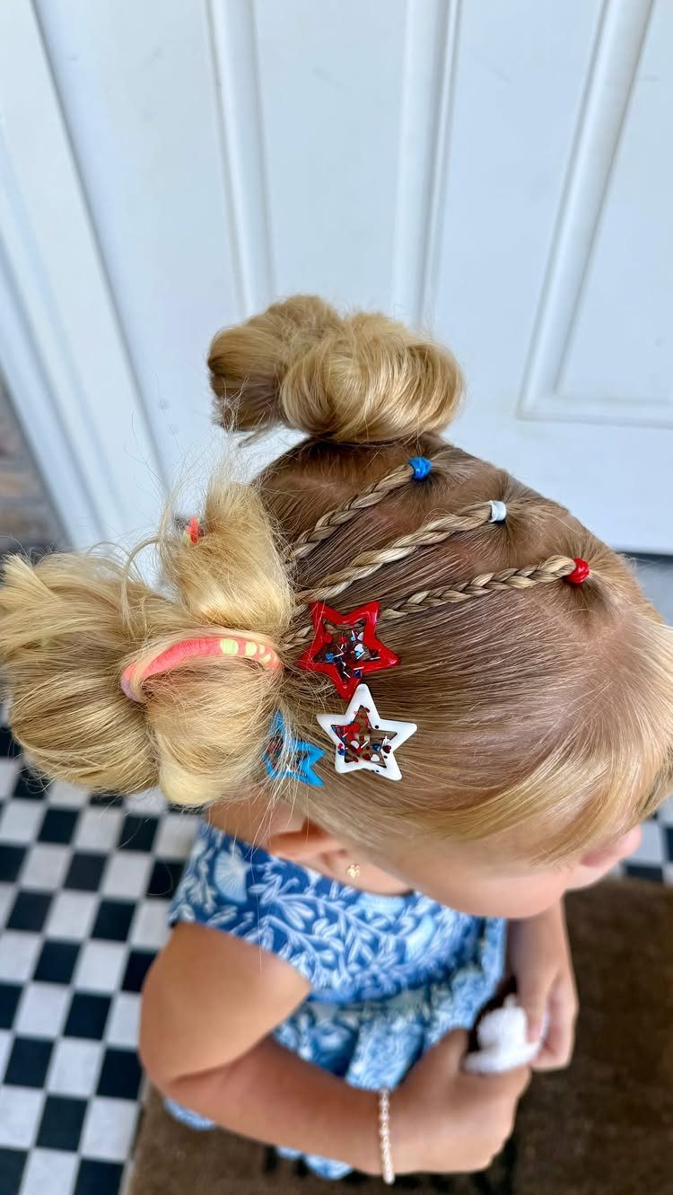 Blonde child's hair in buns with star clips and beaded braids.