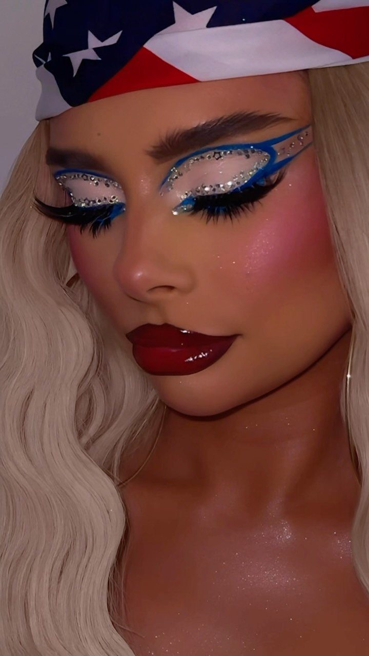 Woman with patriotic headwrap wearing red lipstick and glittery blue rhinestone eye makeup