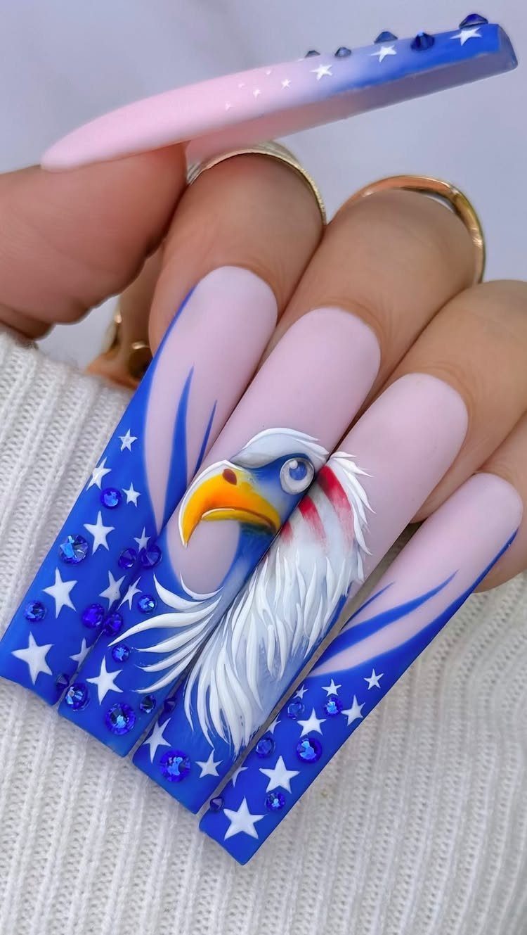 Long coffin nails with a bald eagle painting, white stars, and blue rhinestones.