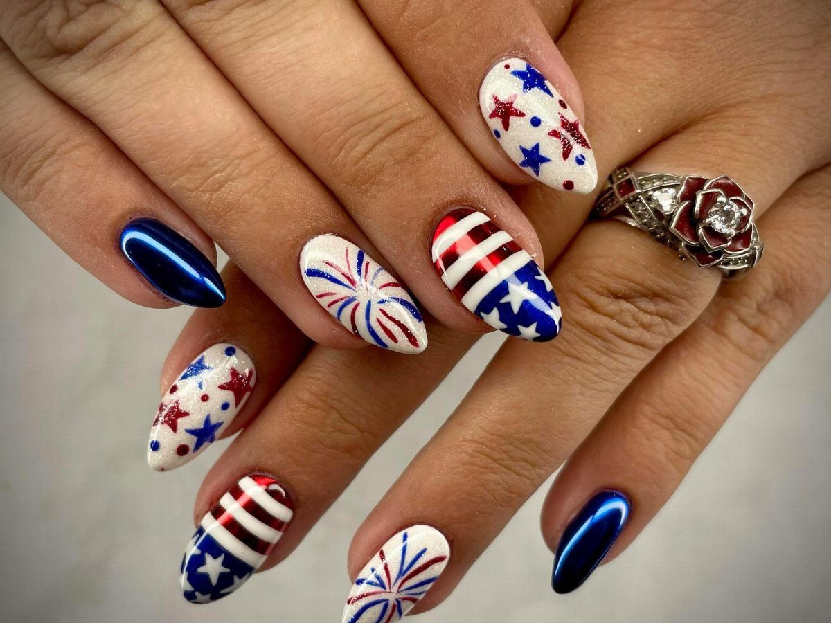 Patriotic almond-shaped nails with red, white, and blue stars, stripes, and fireworks designs.