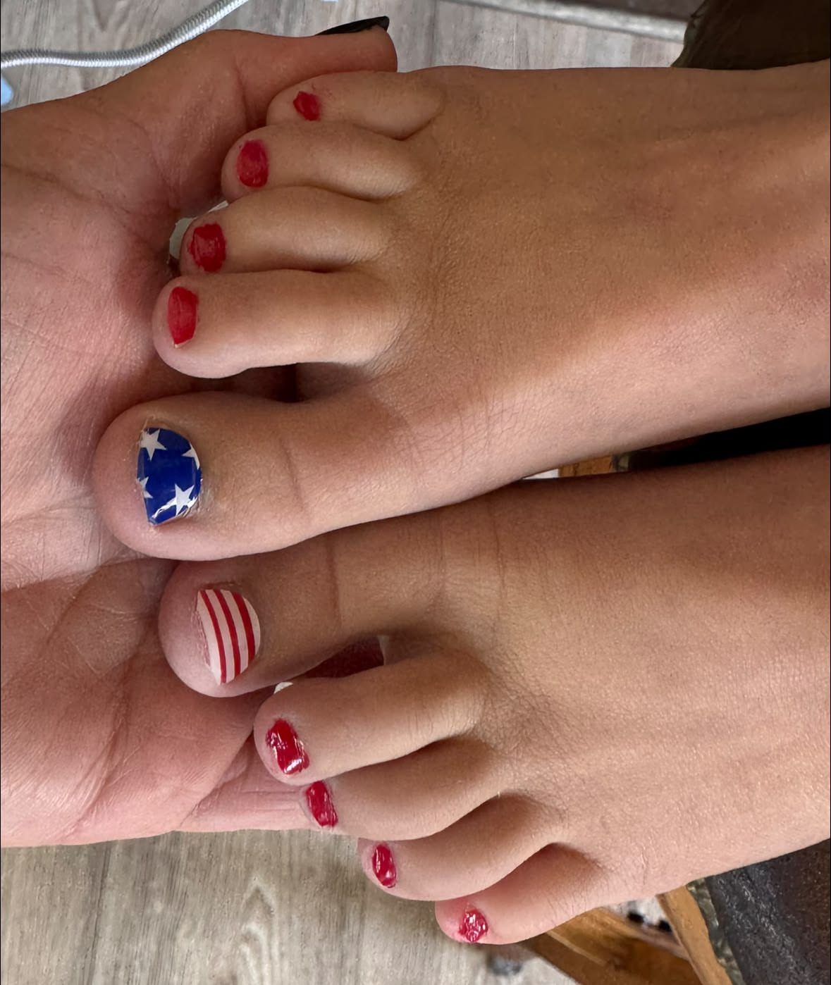 Patriotic pedicured toes featuring white stars on blue and red and white stripes.