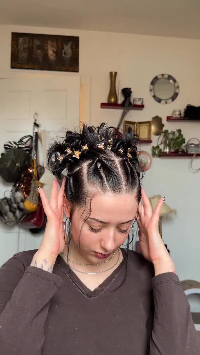 Woman with dark hair styled in an updo featuring gold butterfly clips.