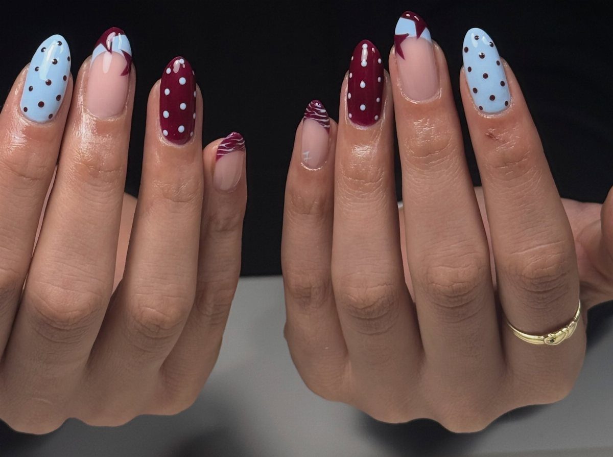 Red, white, and blue acrylic nails with polka dots and patriotic accents.