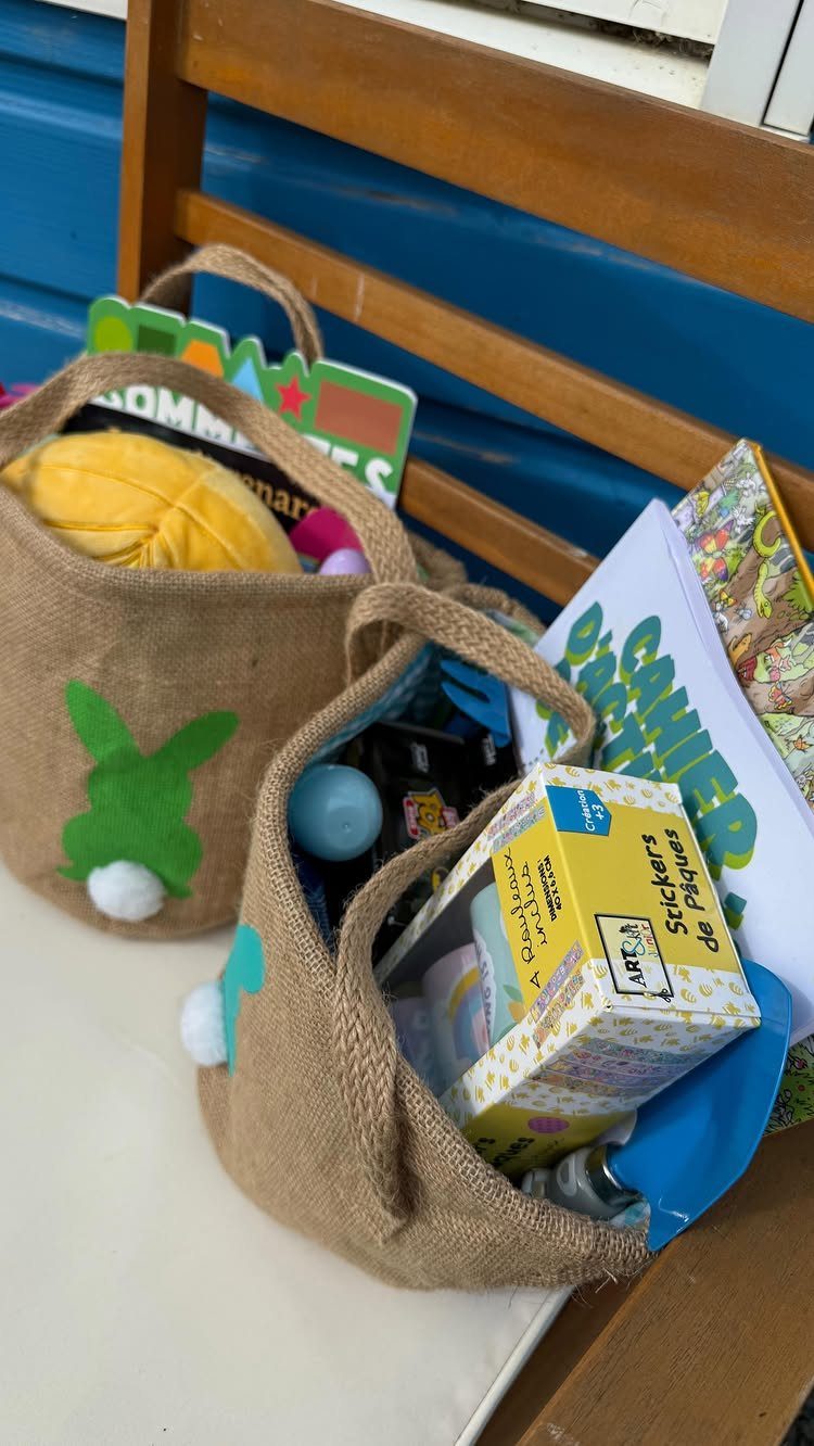 Burlap bunny baskets filled with stickers and books on a wooden bench.