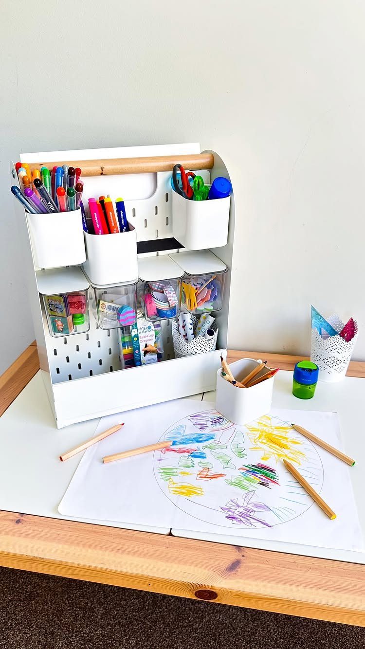 White craft caddy filled with colorful markers and art supplies on a table.