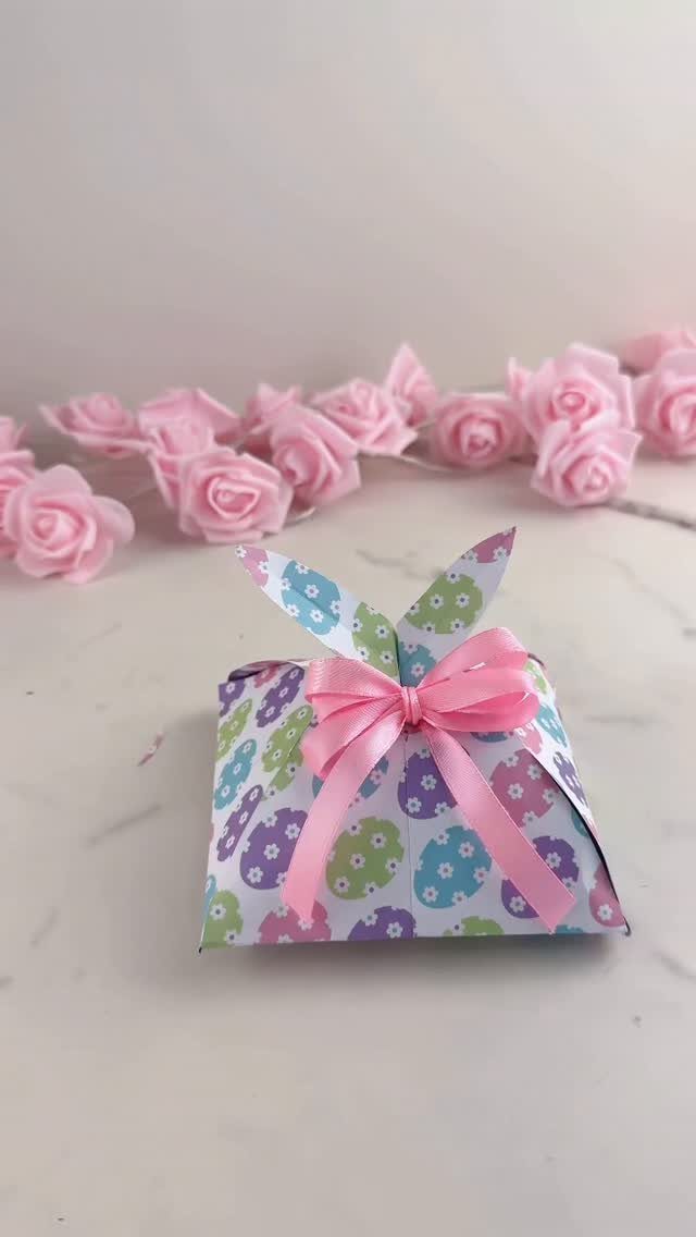Bunny-shaped paper gift box with floral patterns and a pink satin bow.