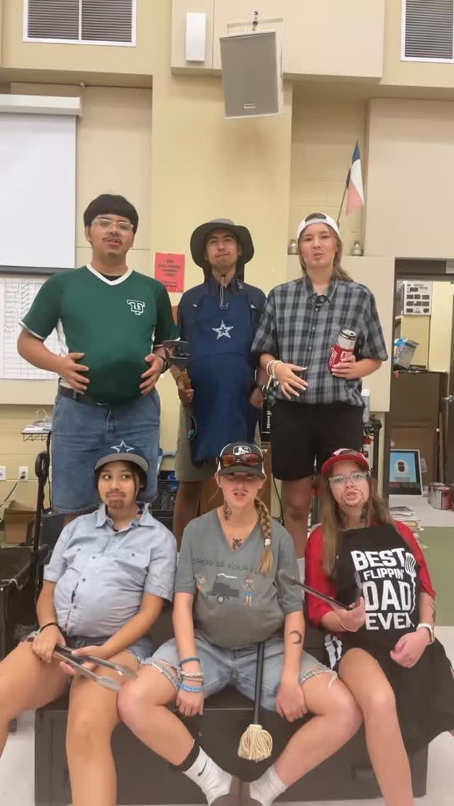 Six people dressed in casual BBQ dad outfits posing together in a room.