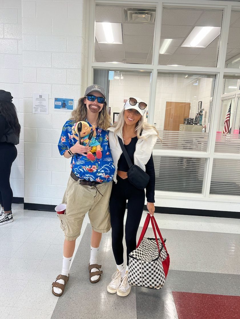 Person wearing a Hawaiian shirt and tan cargo shorts posing with a friend.