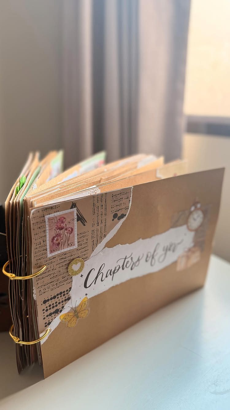 Handmade scrapbook with brown cover and 'Chapters of you' text on white paper.