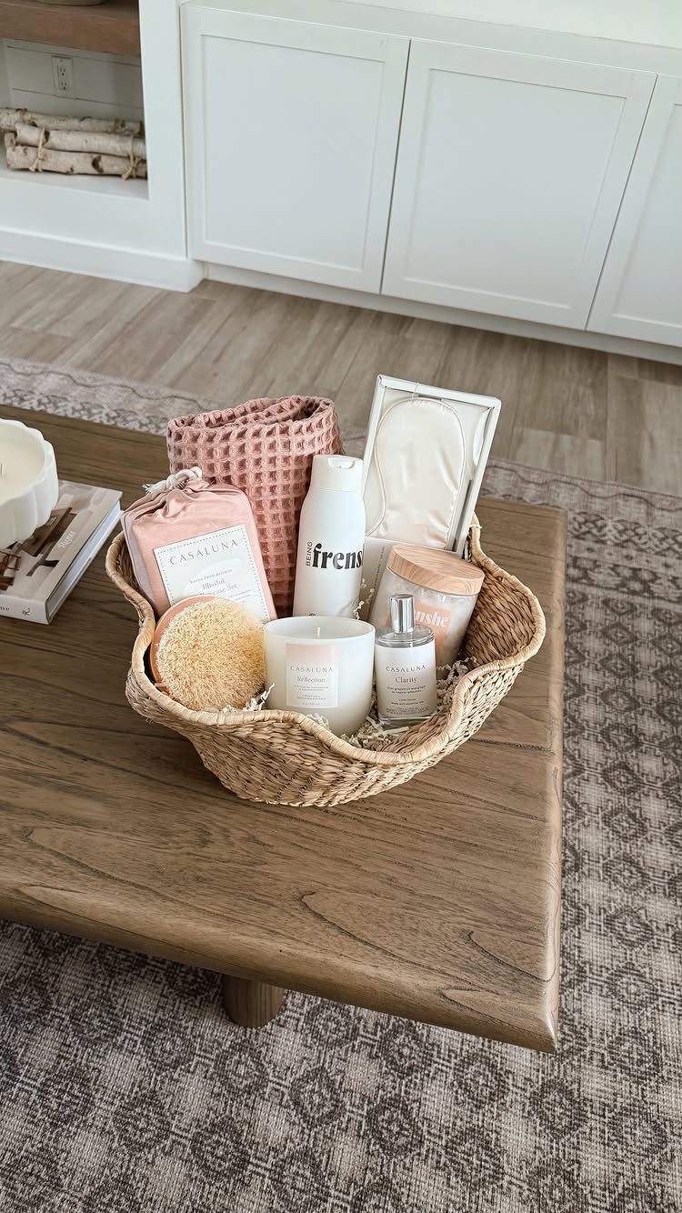 Woven gift basket with skincare products and a candle on a wooden table.
