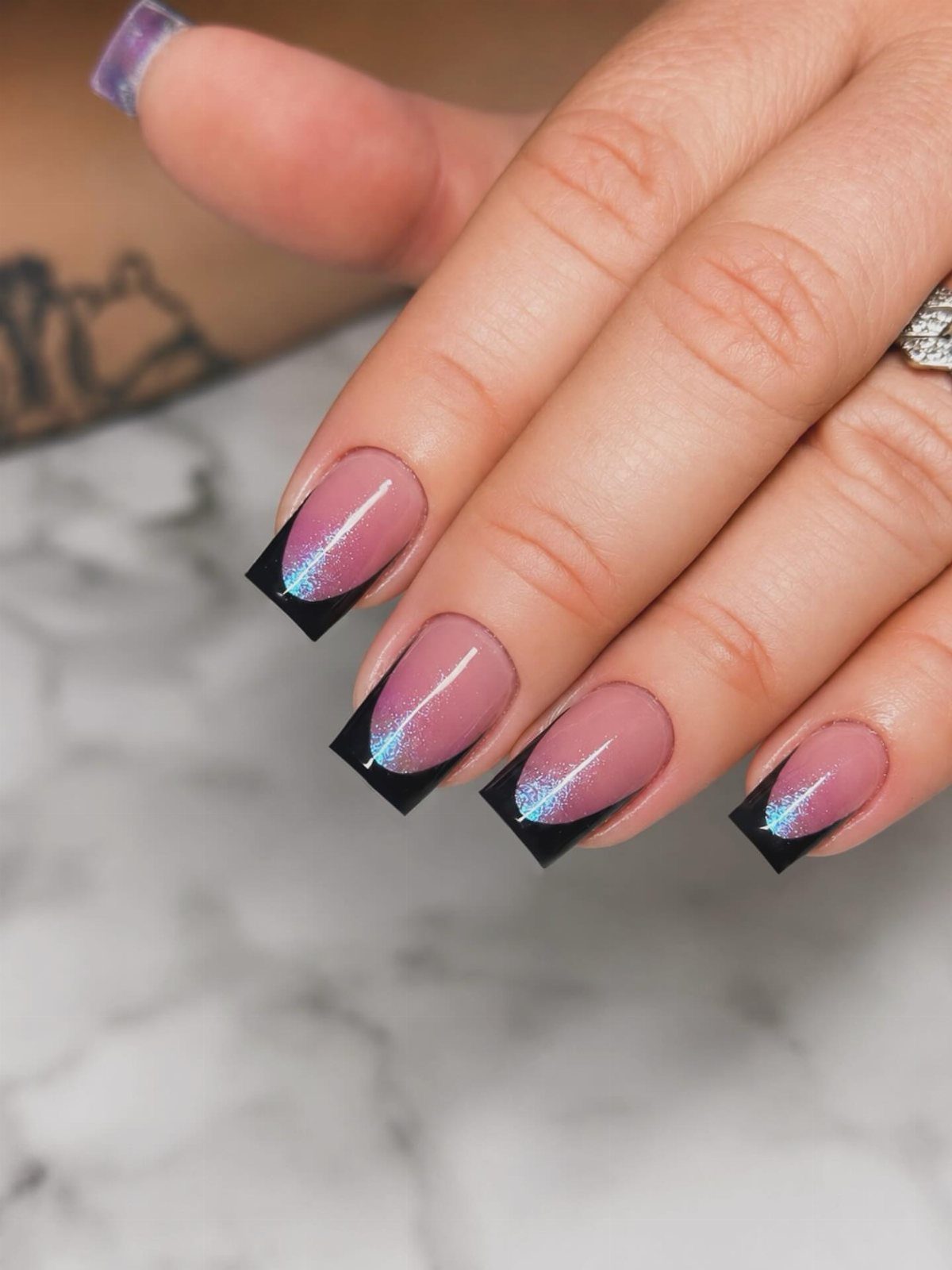 Long coffin nails with shimmering iridescent base and solid black French tips.