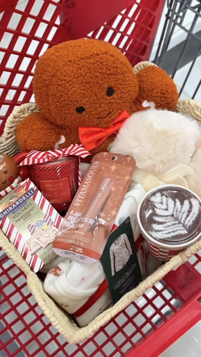 Gift basket with teddy bear, chocolate, and coffee inside a red shopping cart.