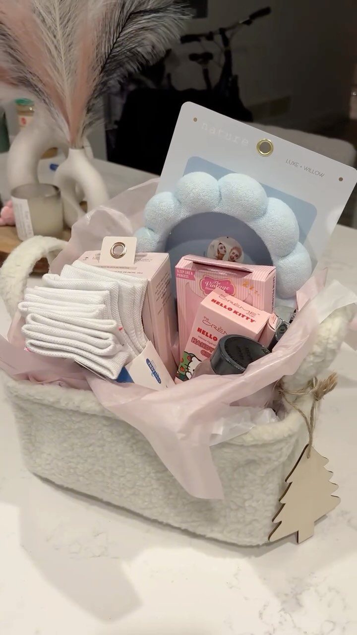 White fuzzy gift basket containing pink boxes, white socks, and a blue headband.
