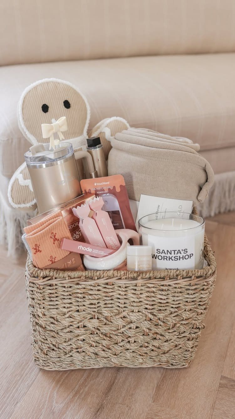 Woven gift basket with a candle, pink socks, and a beige fabric wrap.