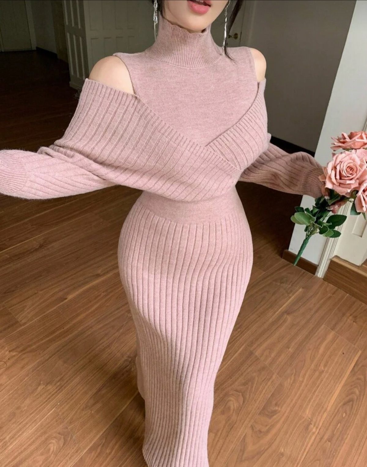 Woman wearing a dusty rose ribbed knit sweater dress with cold-shoulder cutouts.