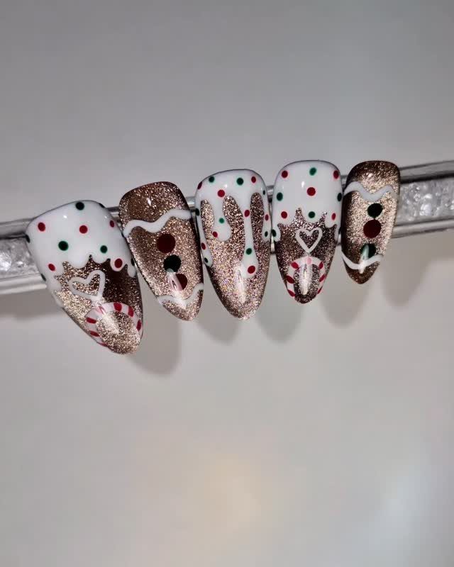 Gingerbread themed nail art with brown glitter, white icing swirls, and colorful dots.