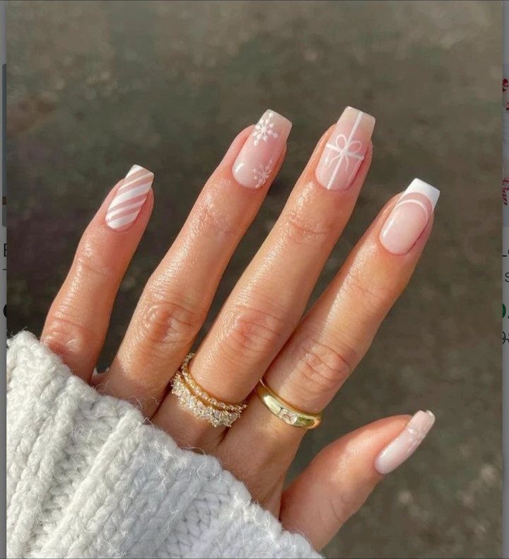 Almond nails with white snowflake, candy cane stripes, and bow holiday designs