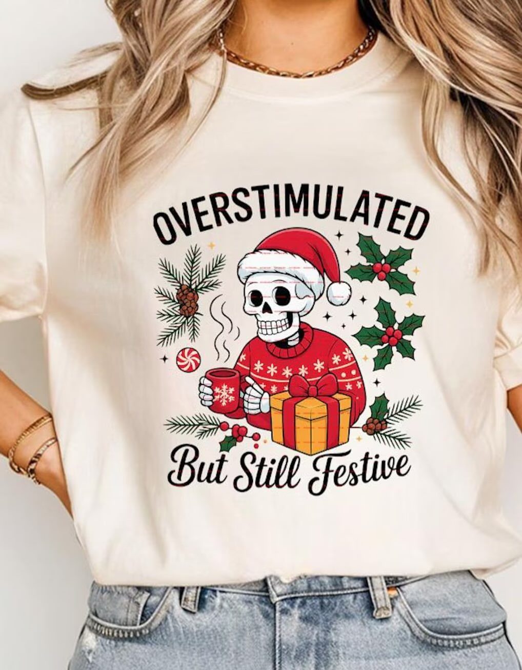 Person wearing a cream t-shirt with a festive skeleton graphic and blue jeans
