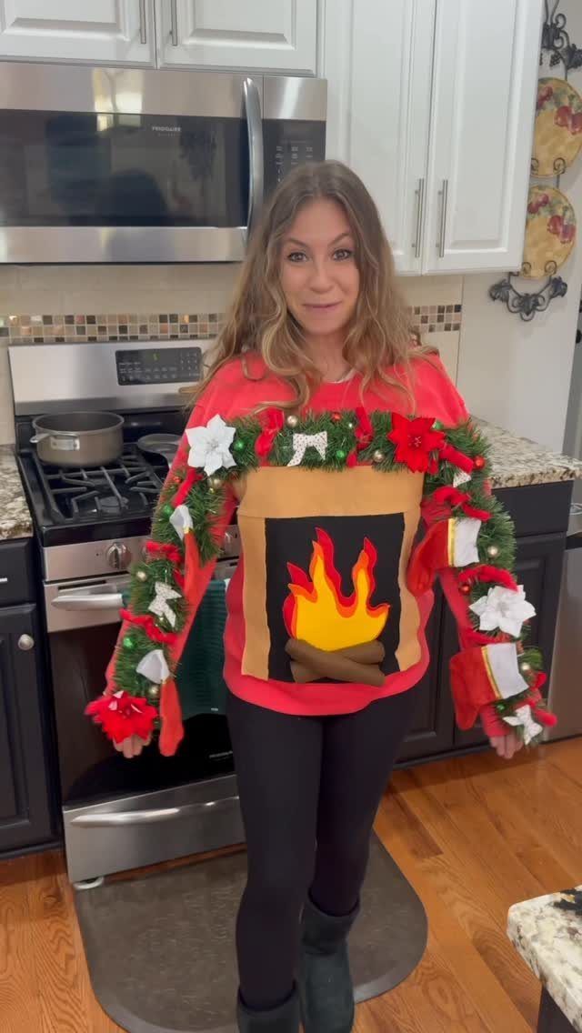 Woman wearing a red ugly Christmas sweater with a 3D fireplace design.