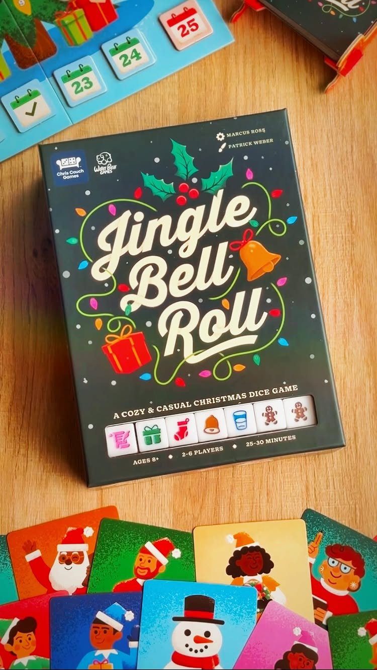 Jingle Bell Roll board game box and colorful character cards on wooden table