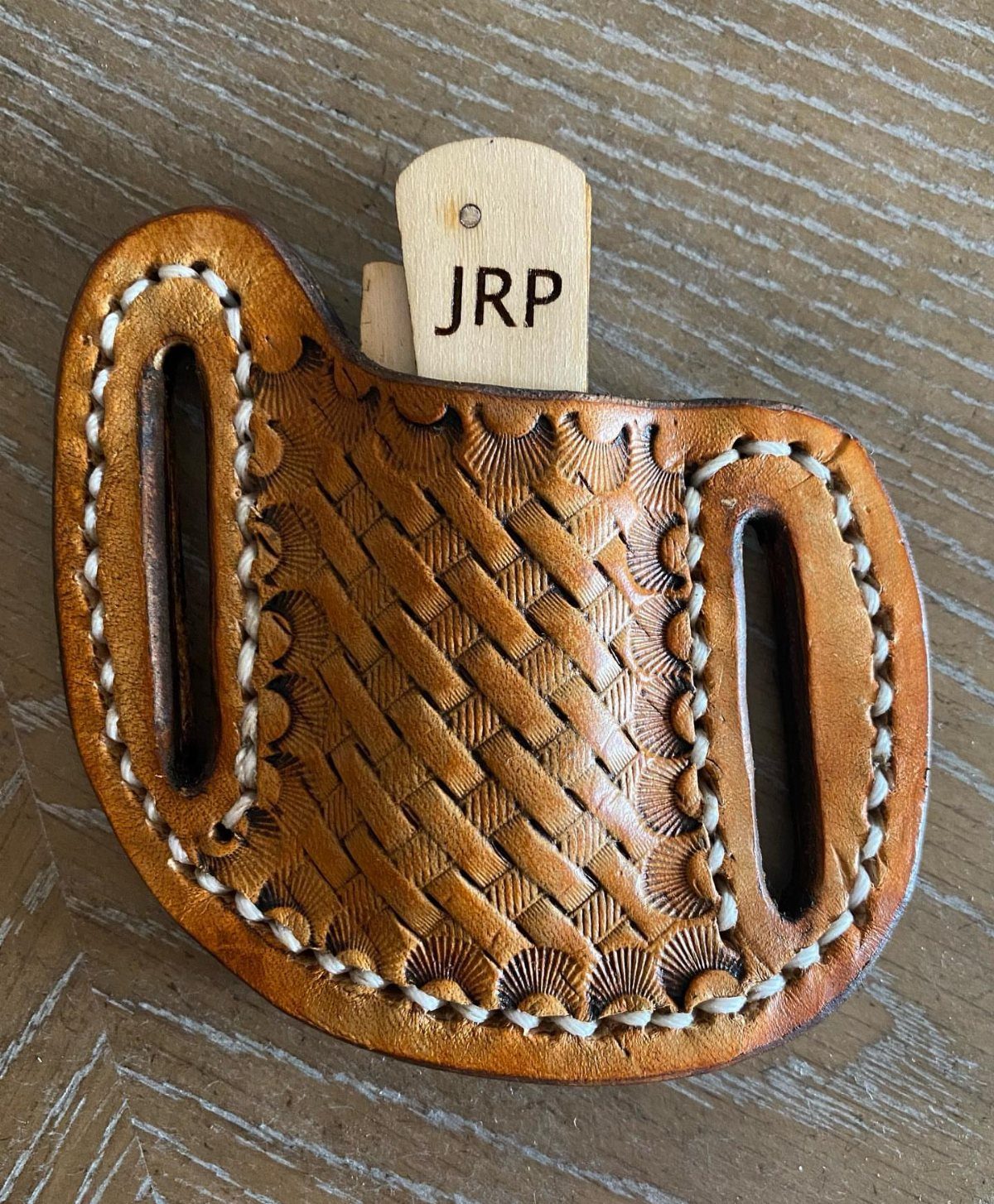Custom pocket knife with engraved wooden handle in a woven leather sheath