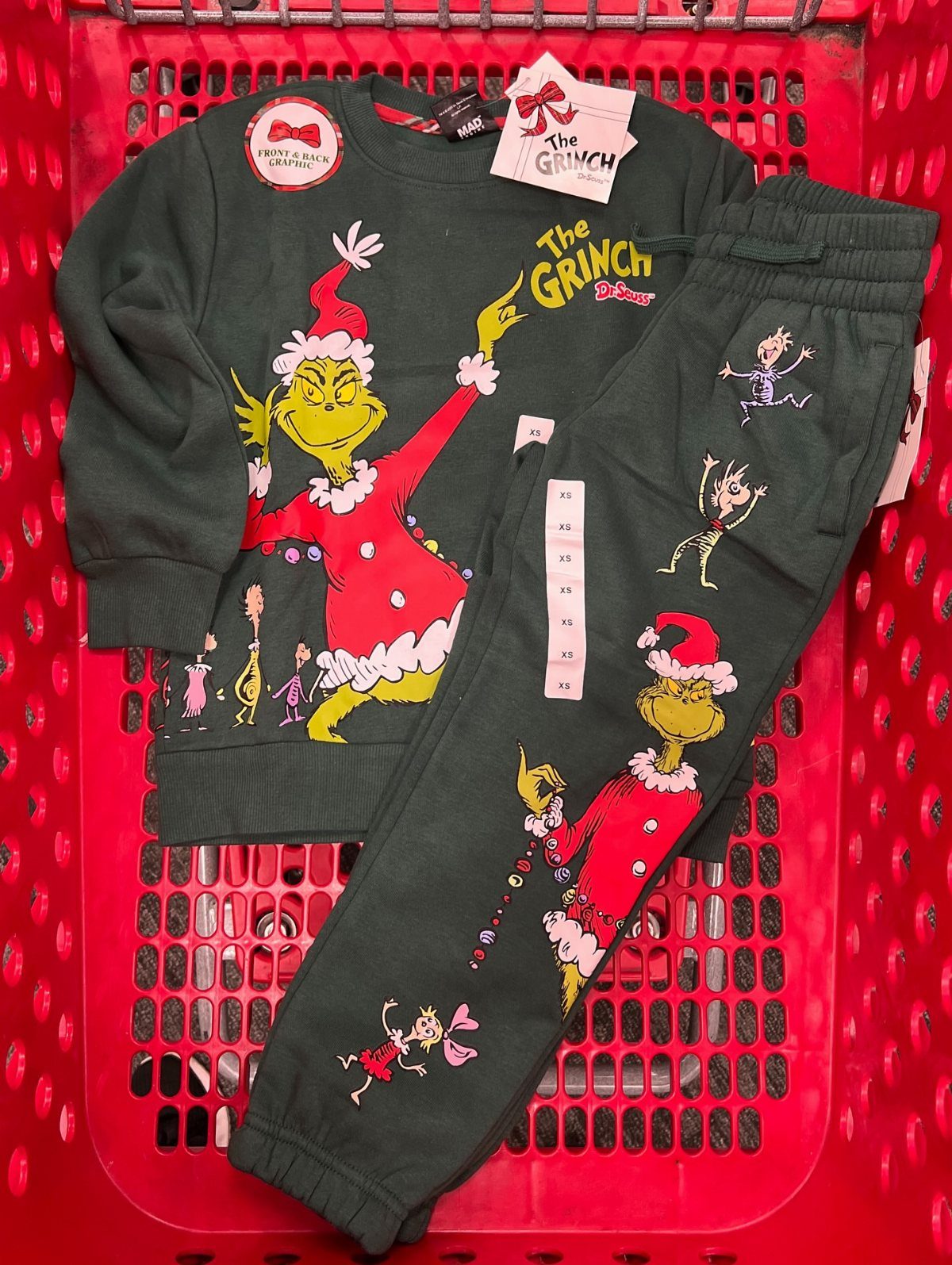 Grinch themed pajama set in a red shopping basket for Christmas gift idea