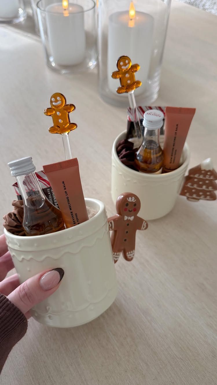 Small white ceramic mugs filled with miniature liquor bottles and gingerbread decorations.