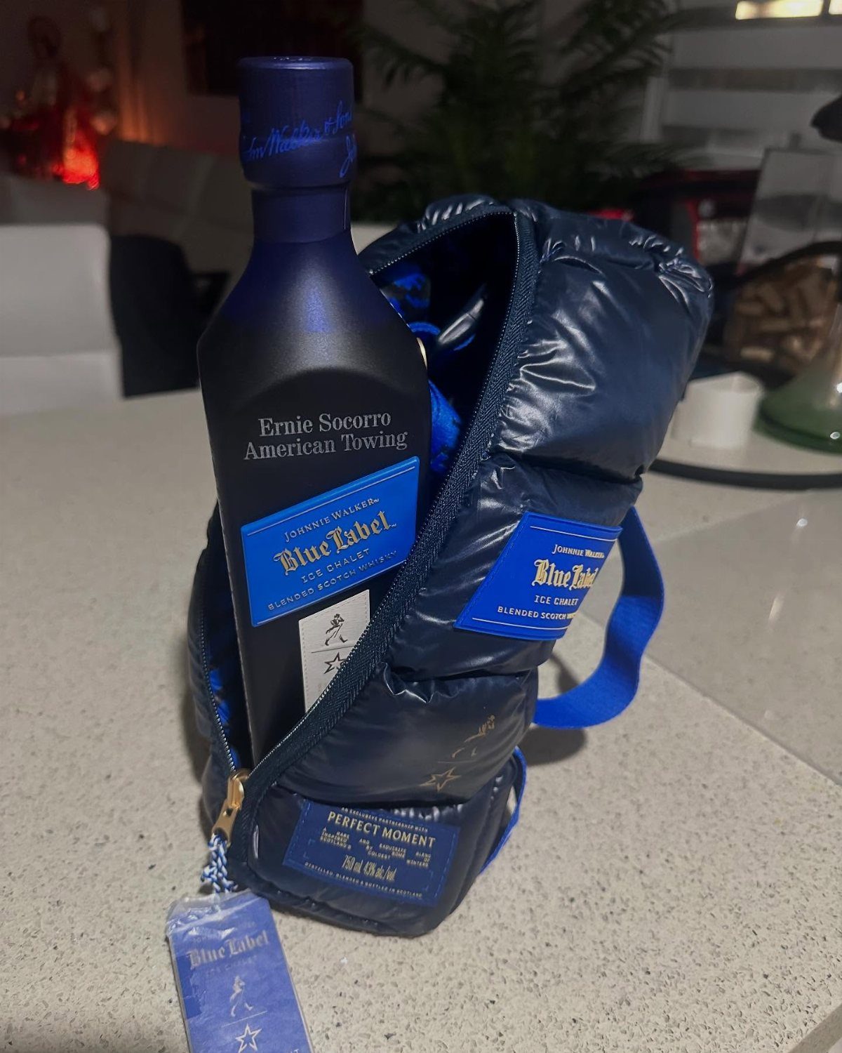Johnnie Walker Blue Label whiskey bottle inside a navy blue puffer jacket carrier.