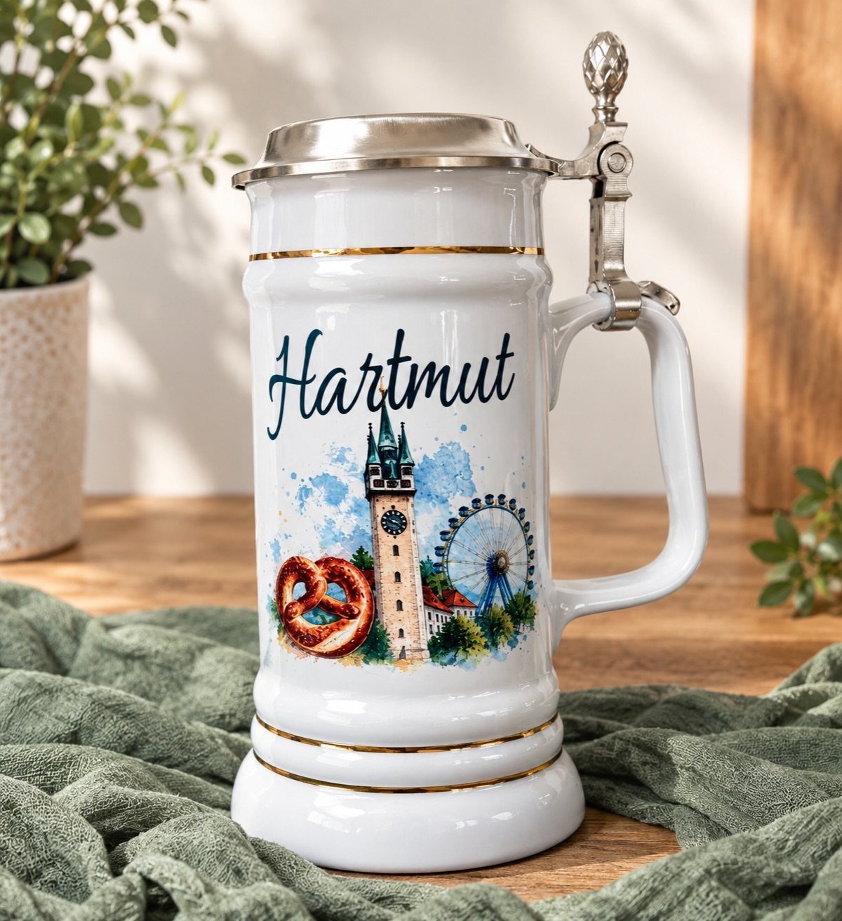 White ceramic beer stein with personalized name Hartmut and colorful city illustration.