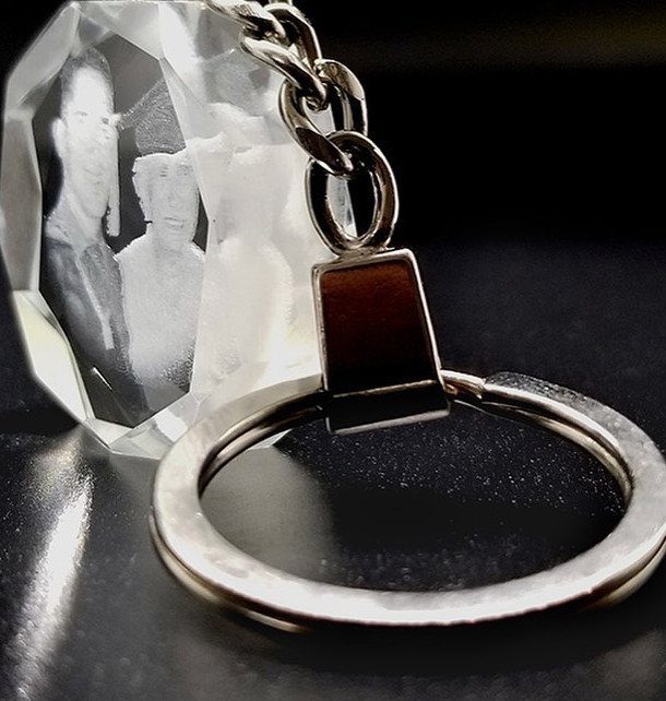 Personalized crystal keychain with a laser-engraved 3D portrait of a couple.