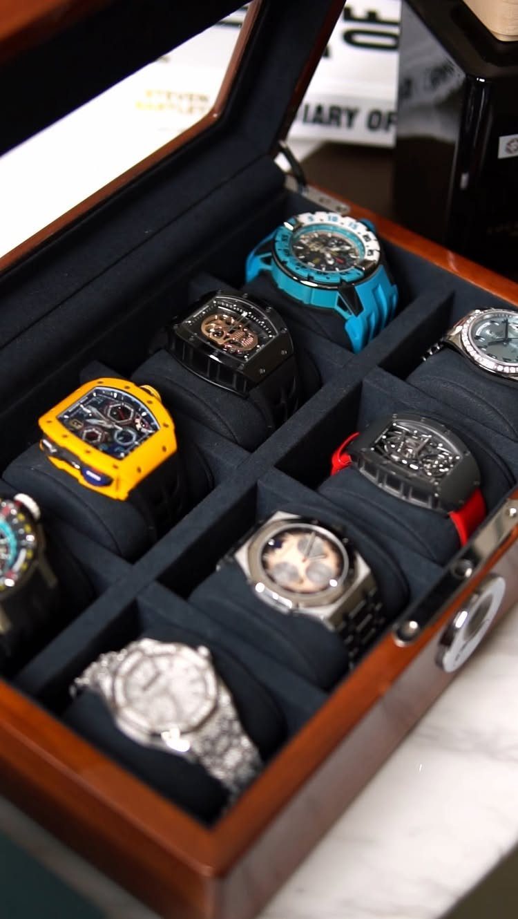 Luxury wristwatches in various colors stored inside a wooden watch display box