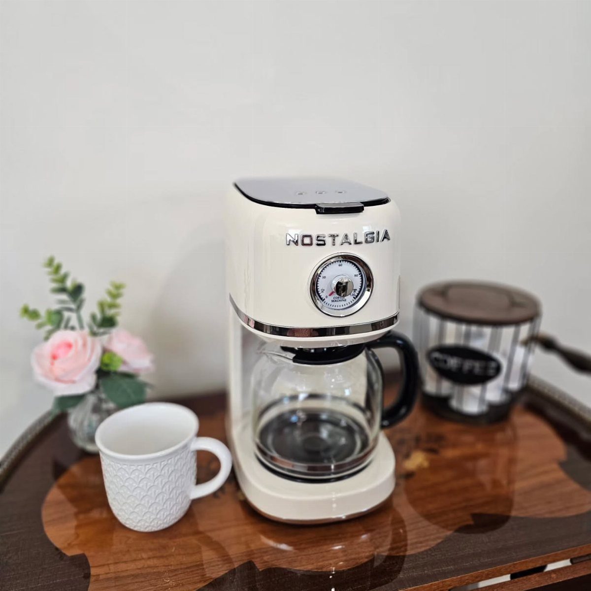 Retro cream-colored drip coffee maker on a wooden tray with a white mug.