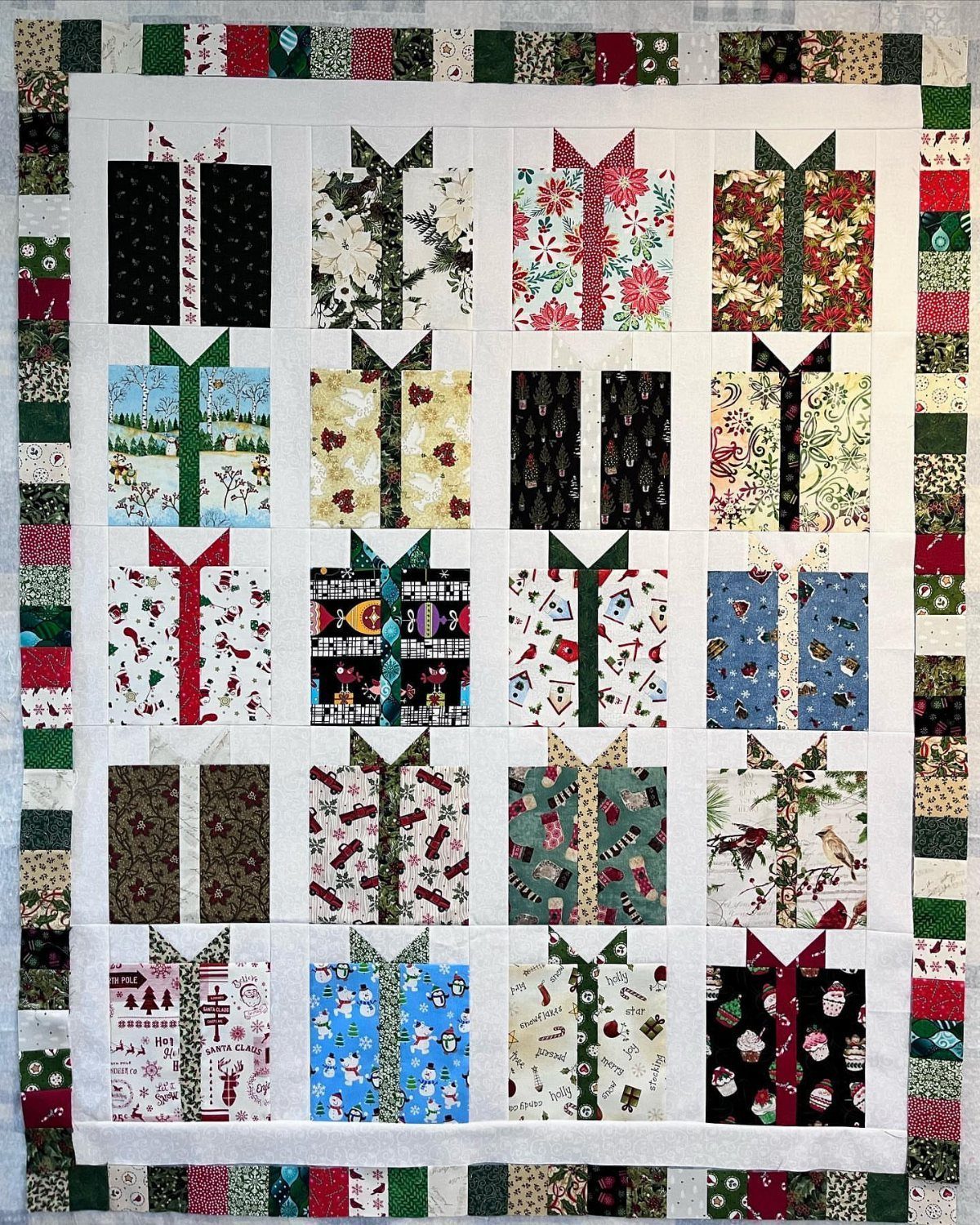 Handmade quilt with a grid of colorful fabric squares shaped like wrapped gifts.