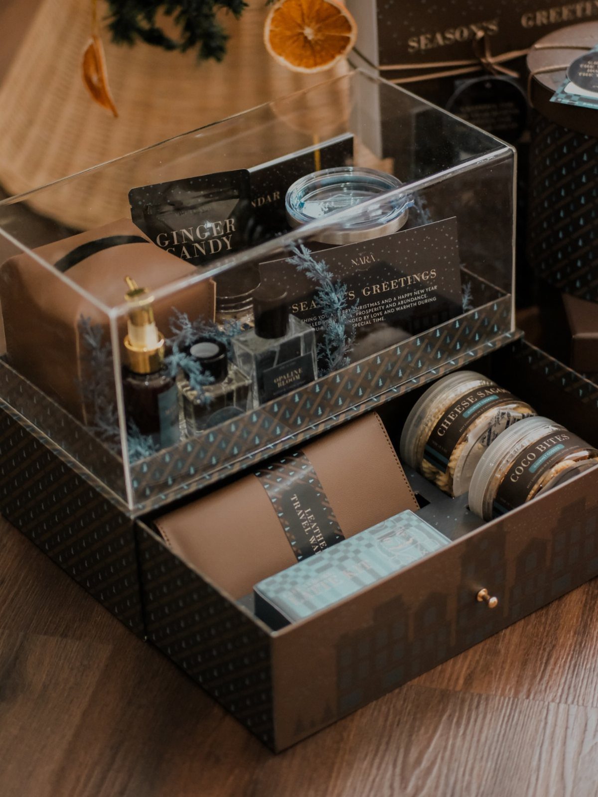 Luxury gift set with gourmet snacks and small bottles in acrylic packaging.