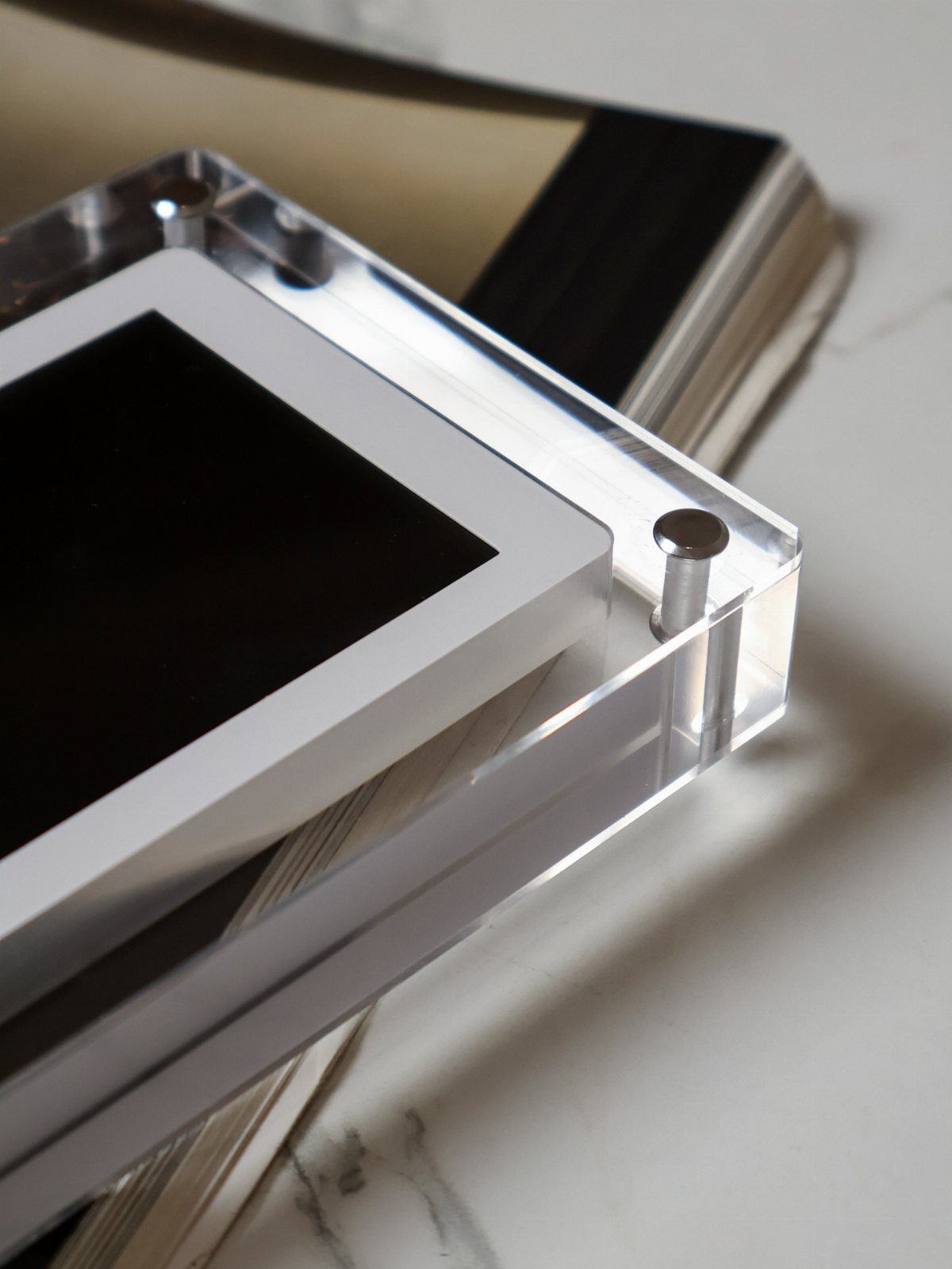 Clear acrylic photo frame with white matting on a white marble surface
