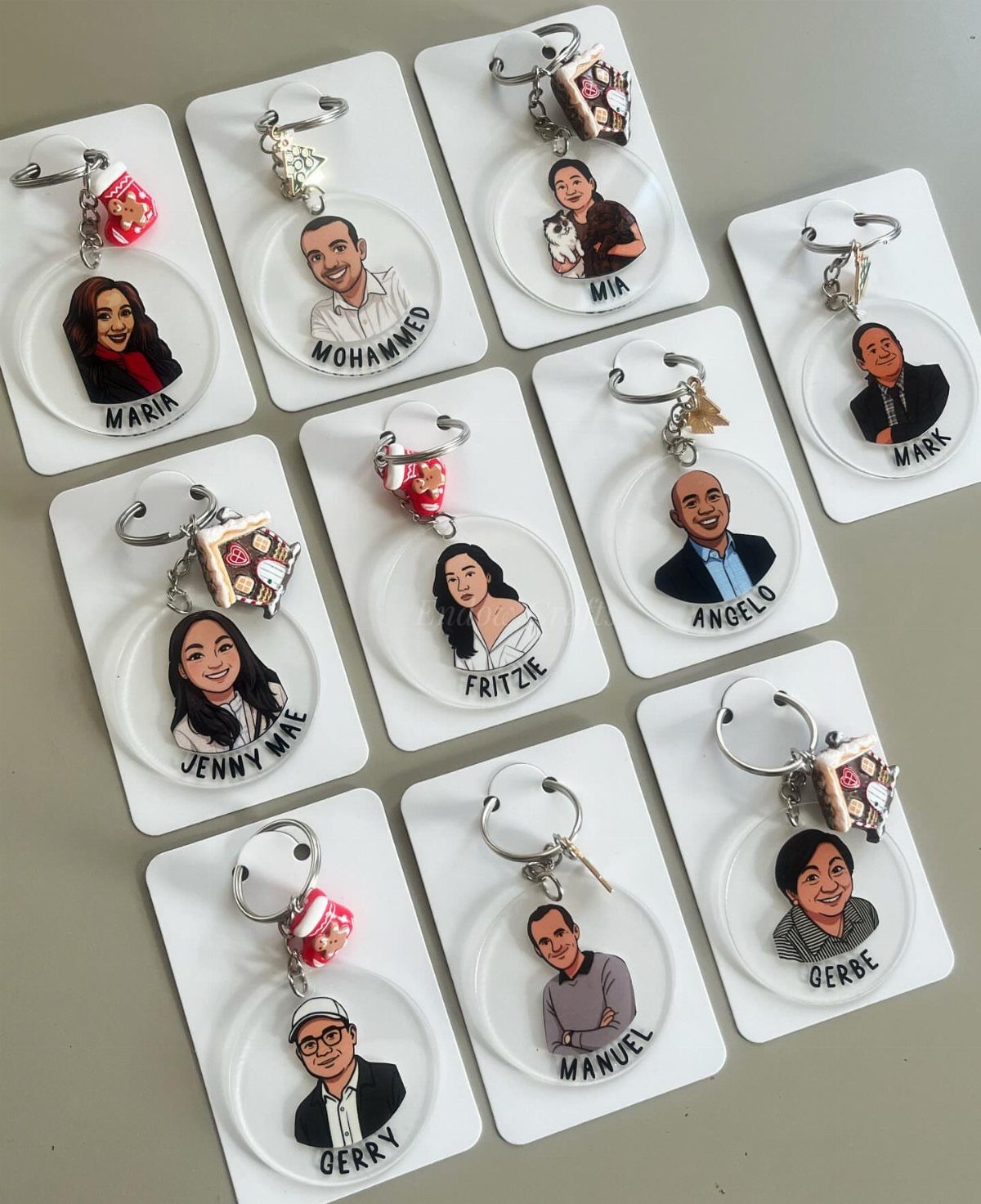 Circular white keyrings with cartoon portraits and names of different people.