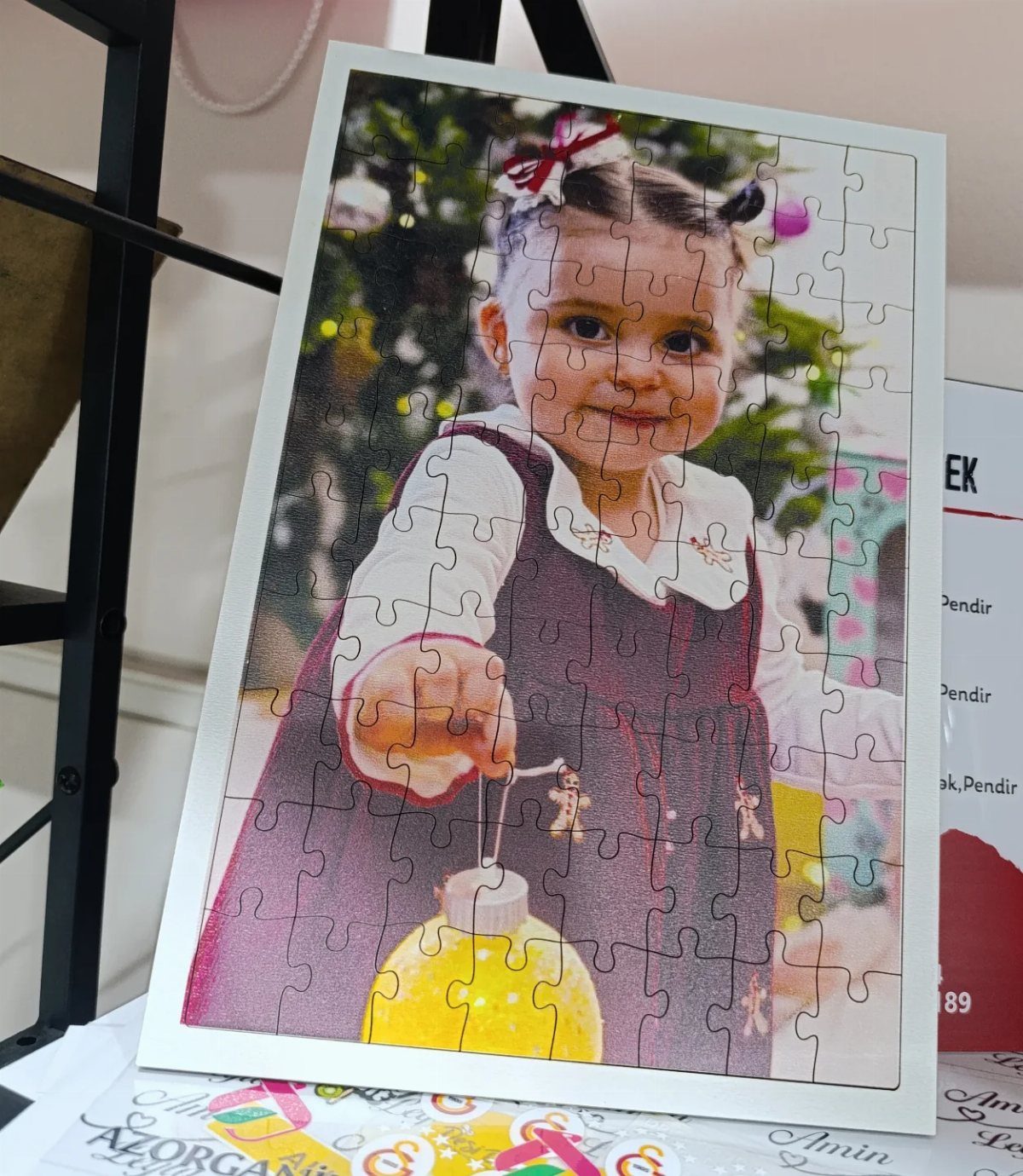 Assembled jigsaw puzzle showing a young girl holding a yellow Christmas ornament.