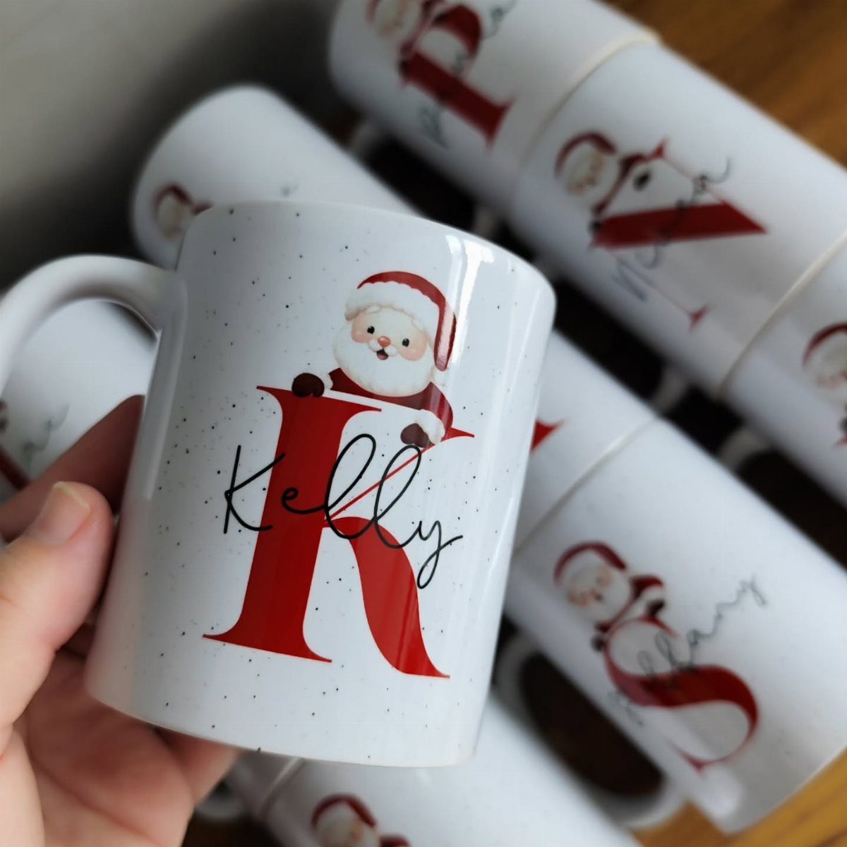 White ceramic mug with a red letter K, Santa Claus, and name Kelly.