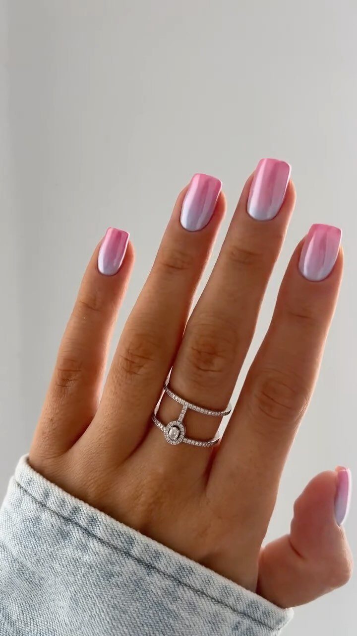 Pink and silver chrome gradient nails on a hand wearing a diamond ring.