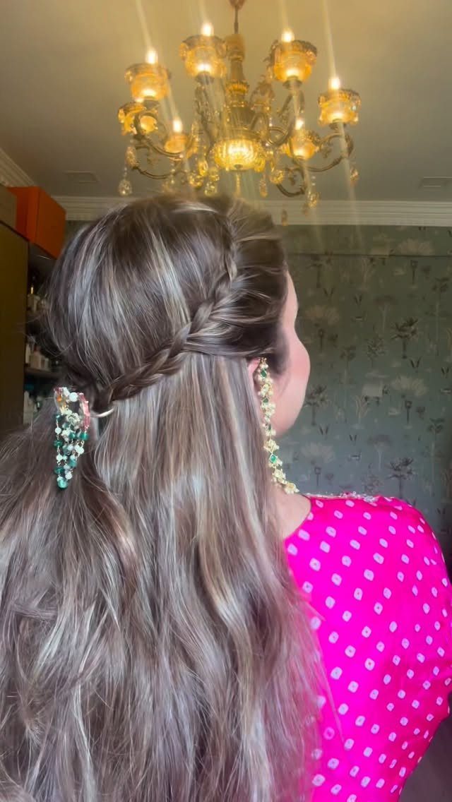 Woman with a side braid and floral hair clip wearing pink polka-dot top