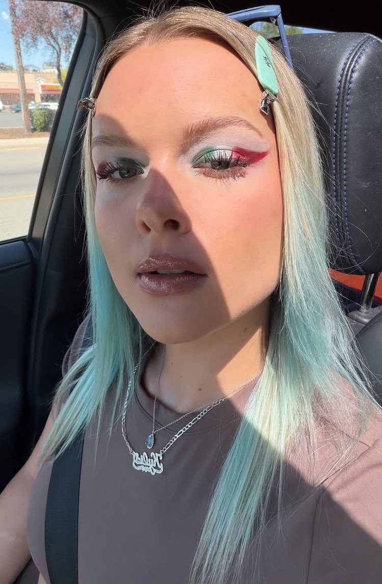 Woman with blue hair wearing green, white, and red Mexican flag eyeshadow.