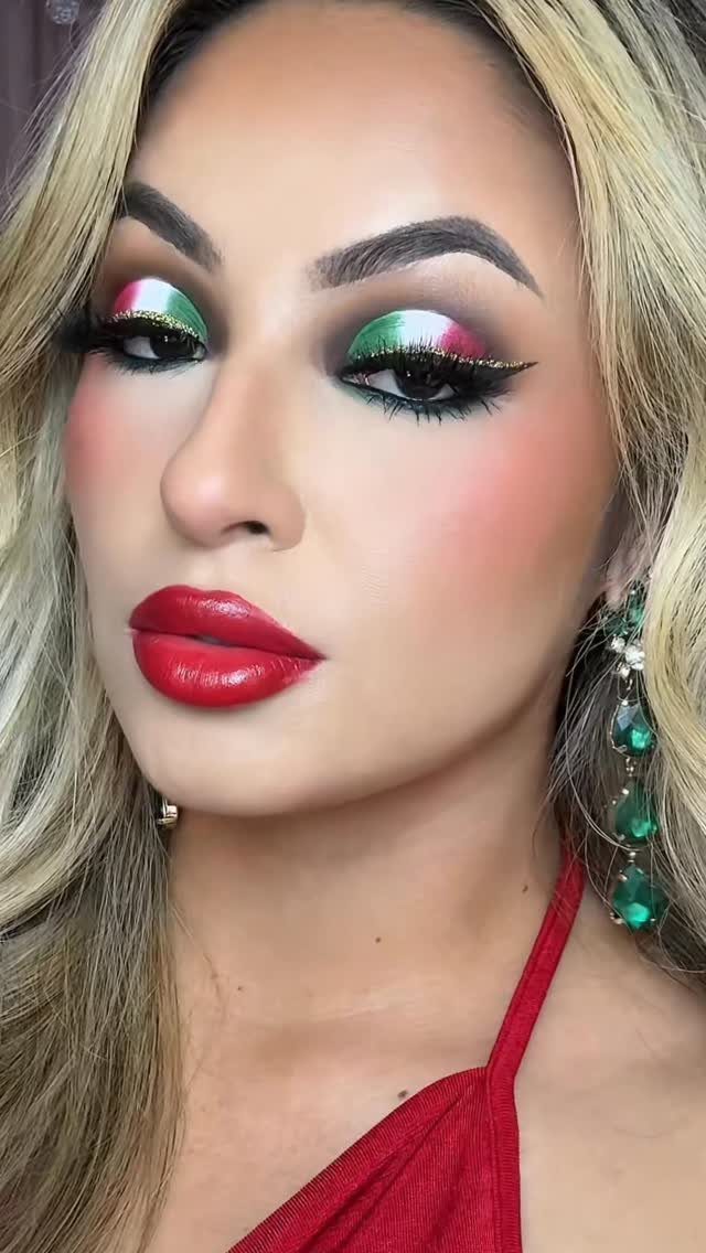 Woman with blonde hair wearing green, white, and red themed makeup and earrings.